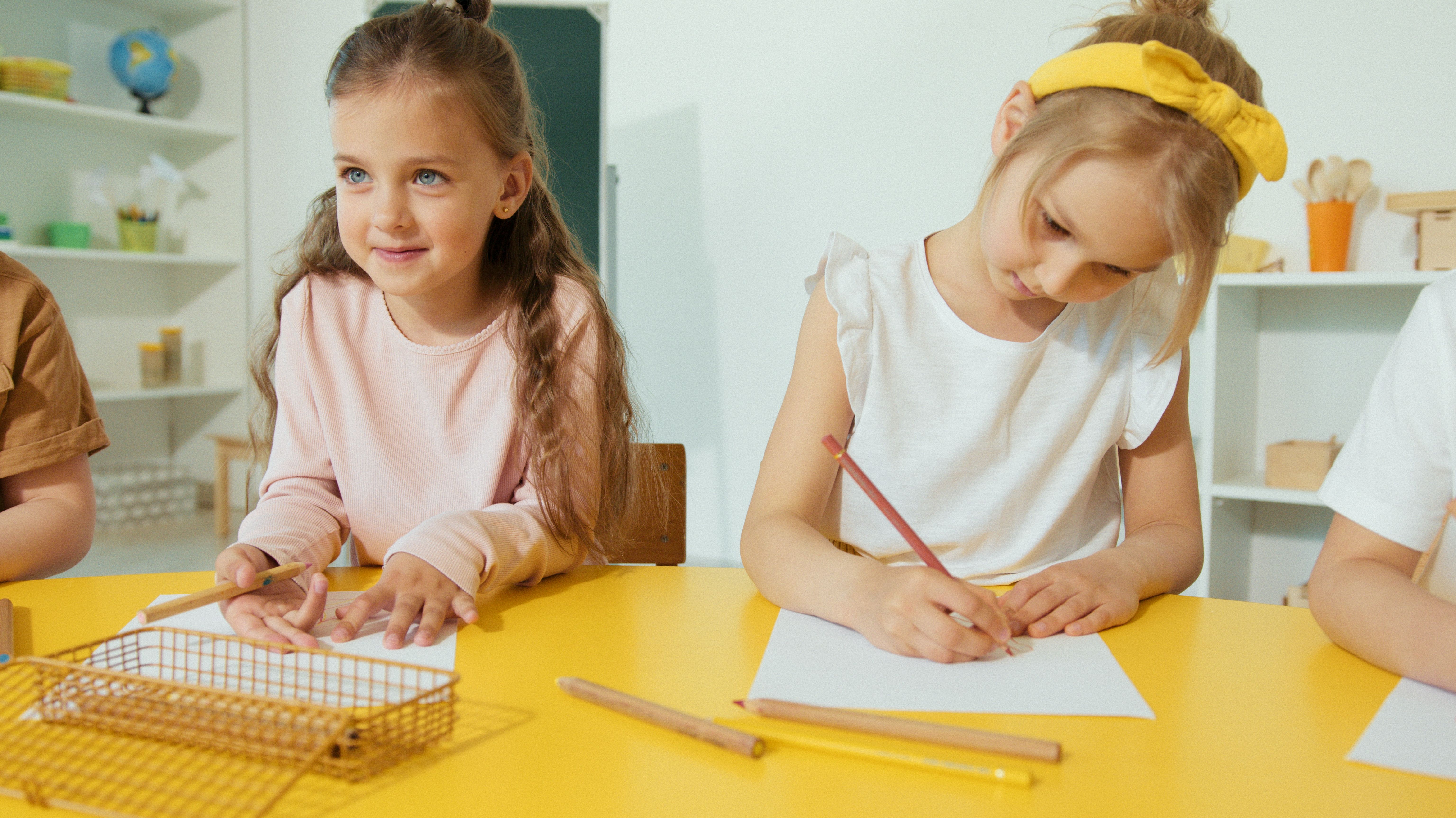 Preschool children drawing together at a classroom table
